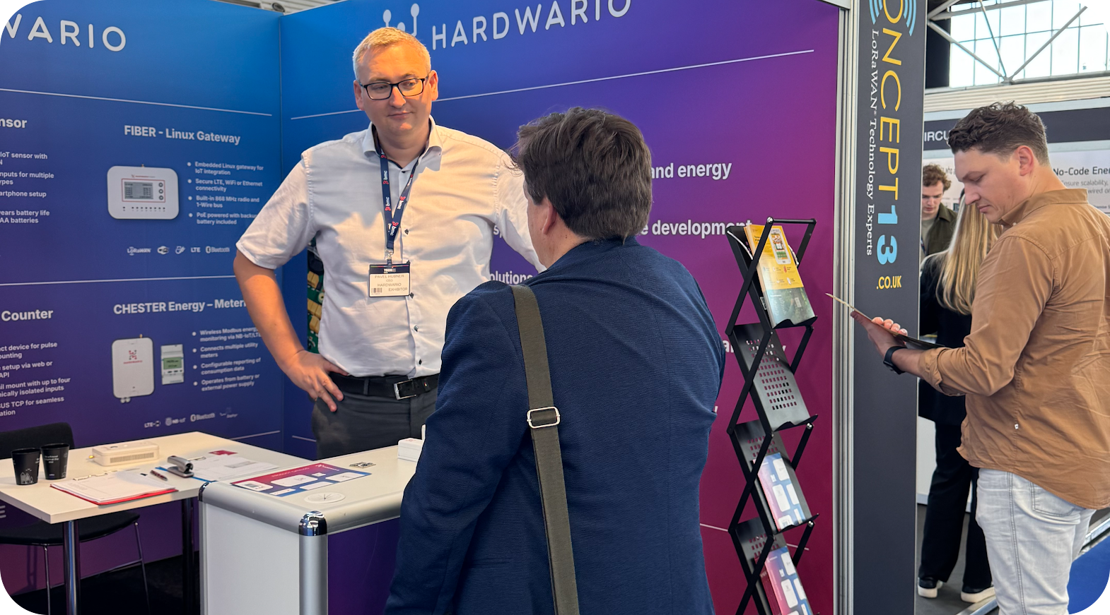 HARDWARIO team at a trade show discussing IoT solutions with customers